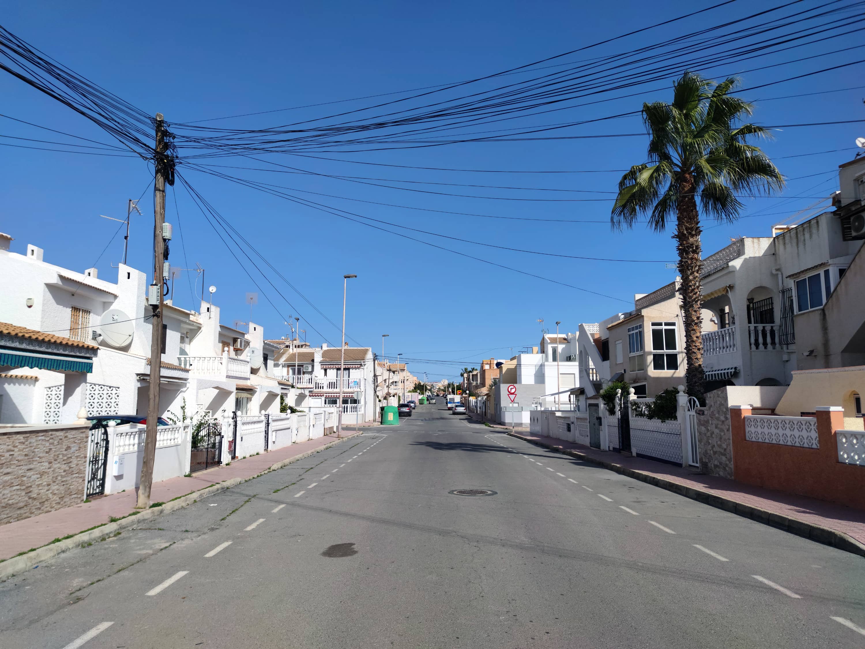 Район Лос Фруталес (Los Frutales) в Торревьехе (Испания). Невысокие дома, широкая дорога, много солнца.